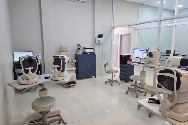 Sala de exames com equipamentos de diagnóstico oftalmológico lado a lado