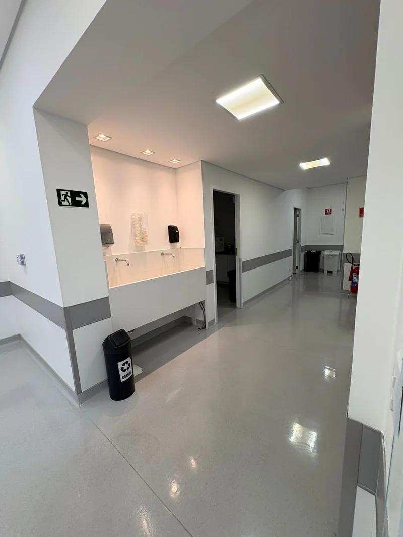 Corredor hospitalar MIRA com estação de higiene e sinalização de emergência