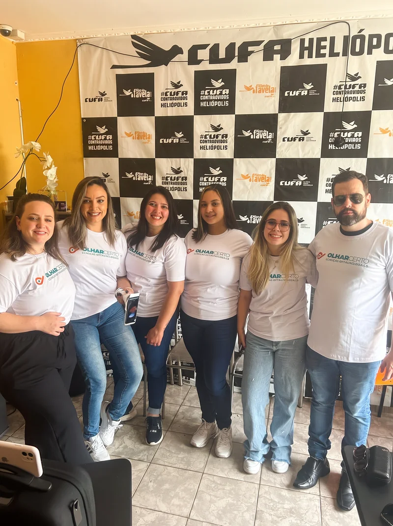 Equipe Olhar Certo na CUFA Heliópolis com backdrop da Central Única das Favelas