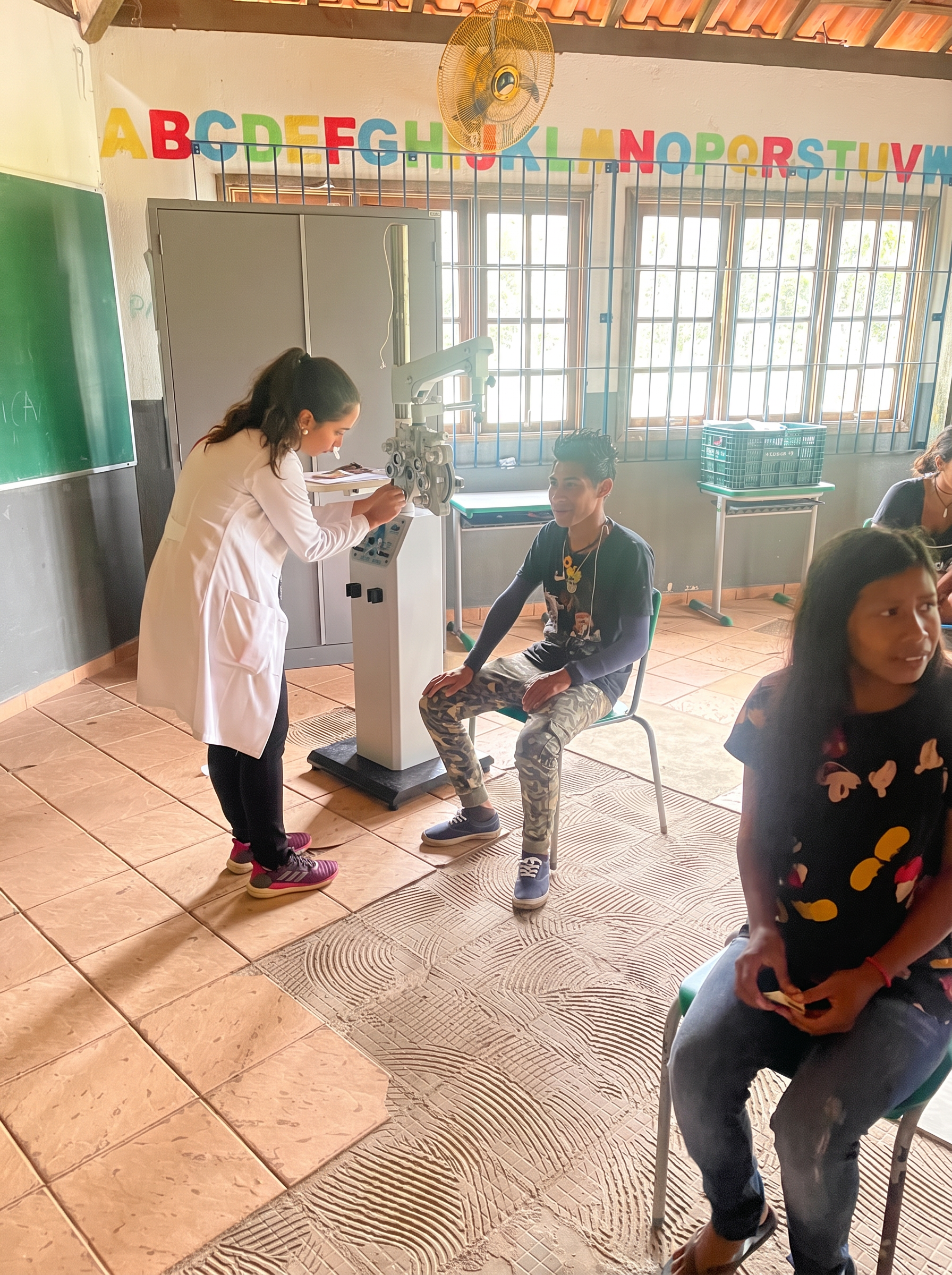 Profissional realizando exame de refração com foróptero em jovem indígena na escola da aldeia